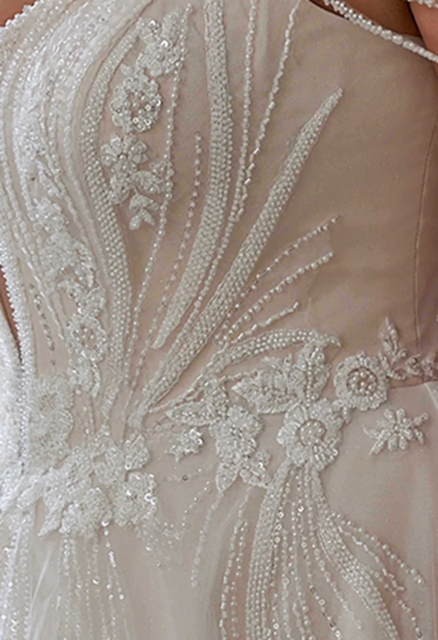 Gown has sheer fabric with intricate beadwork and lace, elegant and delicate.