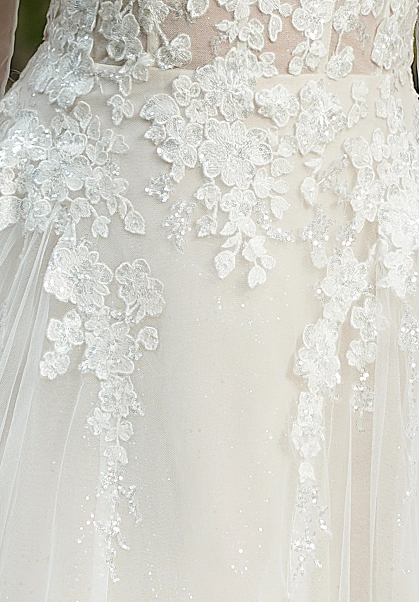 Intricate floral lace embellishes the gown.