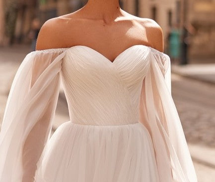 The structured corset bodice with a sweetheart neckline highlights the natural curves of the bride
