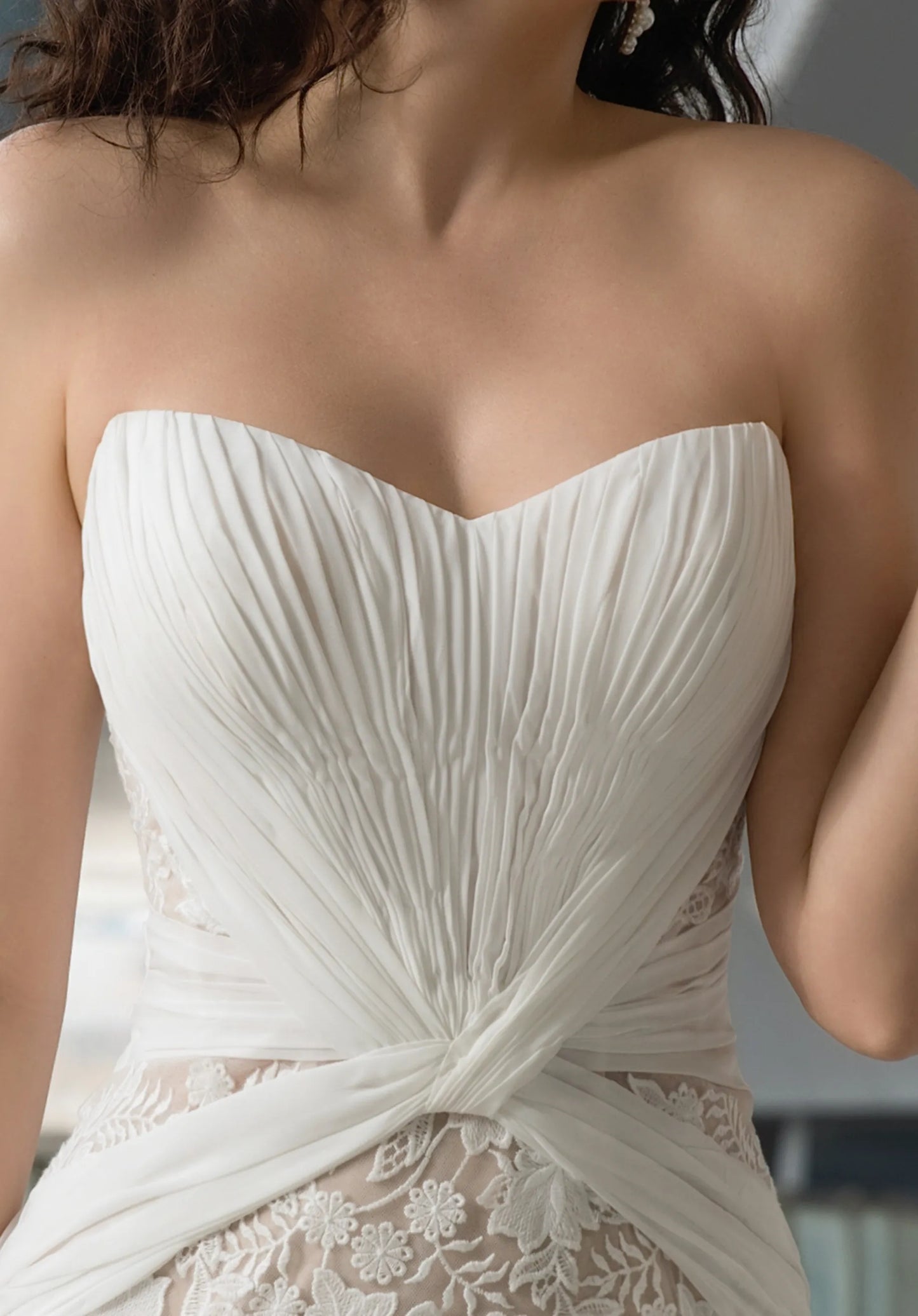 The sweetheart neckline is elegantly pleated, creating a soft, romantic look.