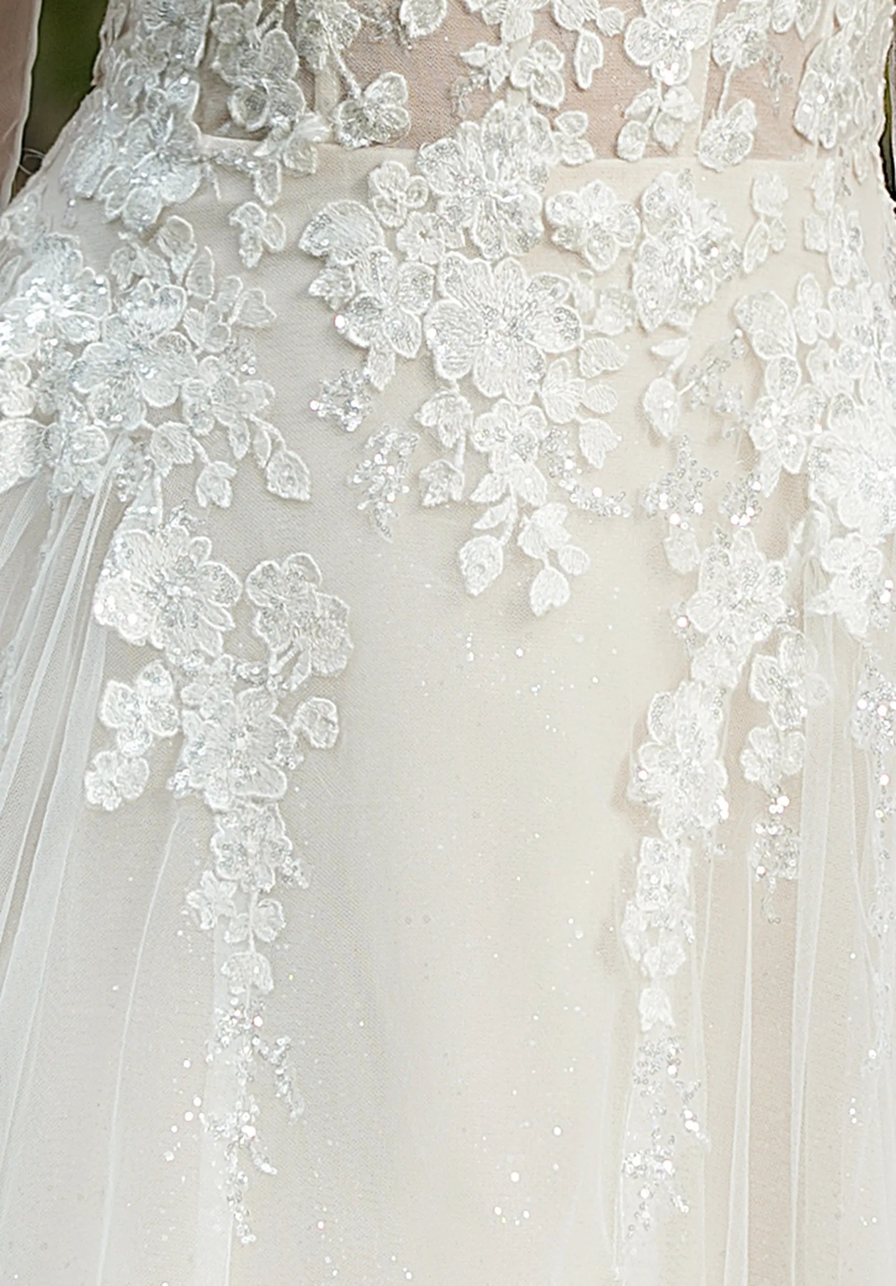 Intricate floral lace embellishes the gown.
