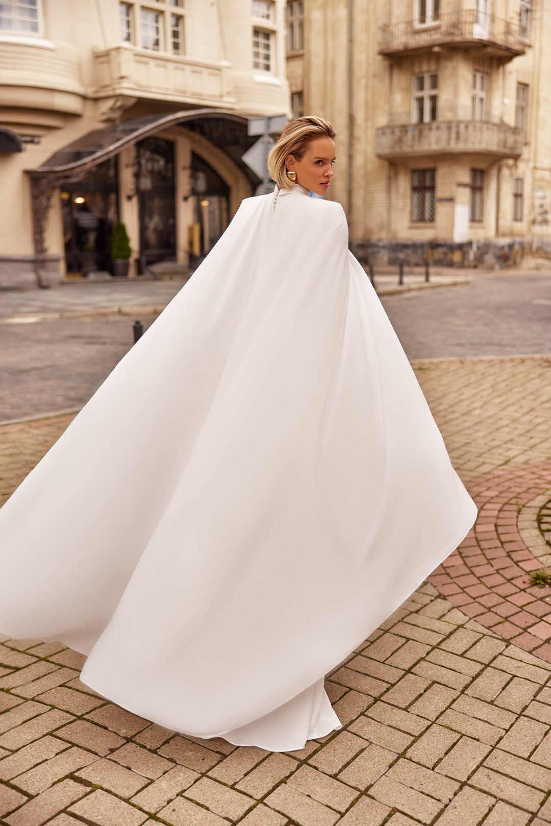 Back view of Bride wearing  the LIRA Wedding Gown With Cape,