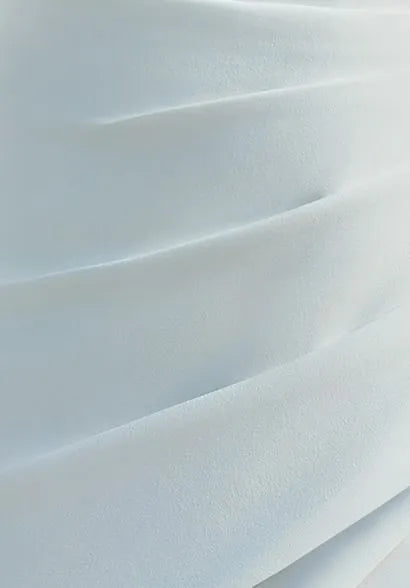 Fabric texture shot, presenting the smooth crepe material with refined draping, emphasizing the dress’s flow and quality.